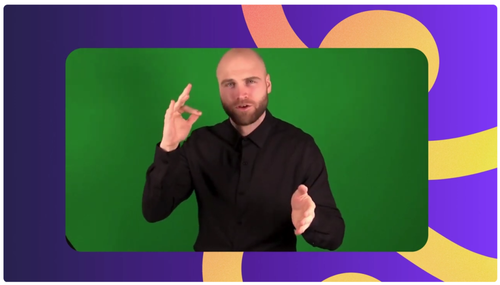 Screenshot of a white man wearing a dark shirt in front of a green screen using American Sign Language